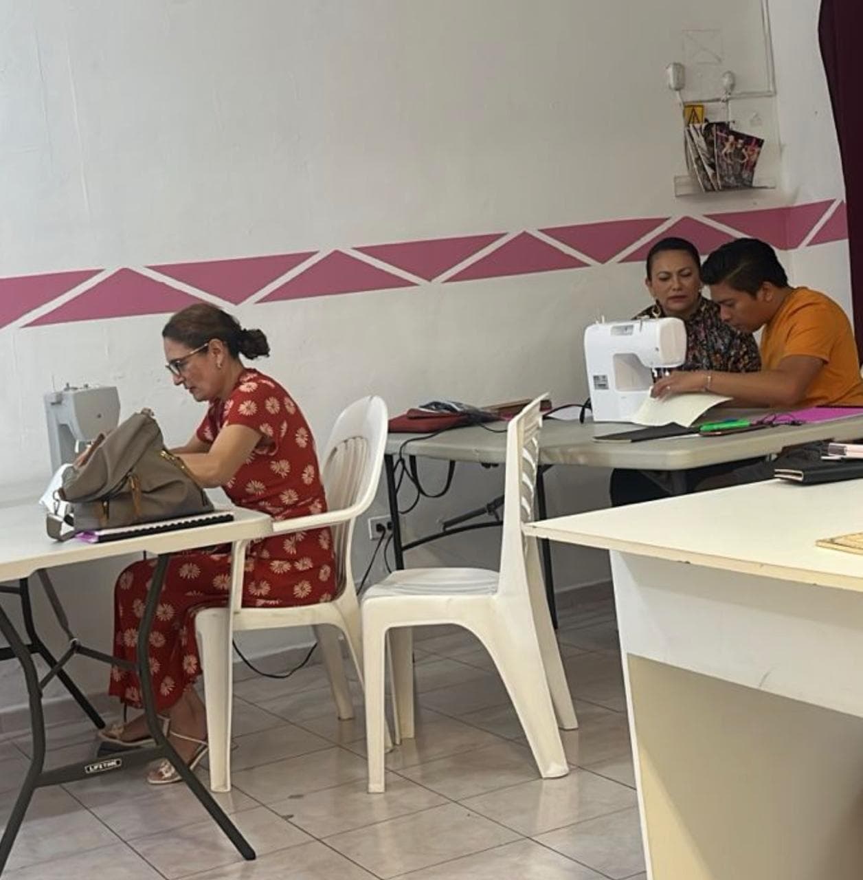 Alumnas practicando en máquinas de coser durante la clase
