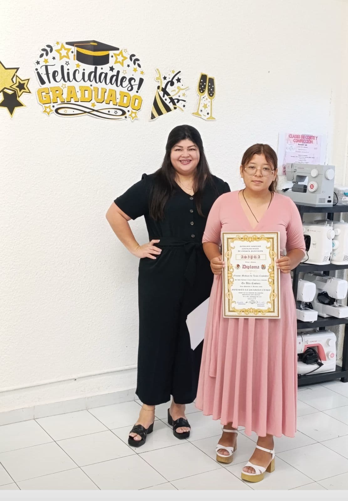 Alumna recibiendo su diploma de Alta Costura junto a su maestra