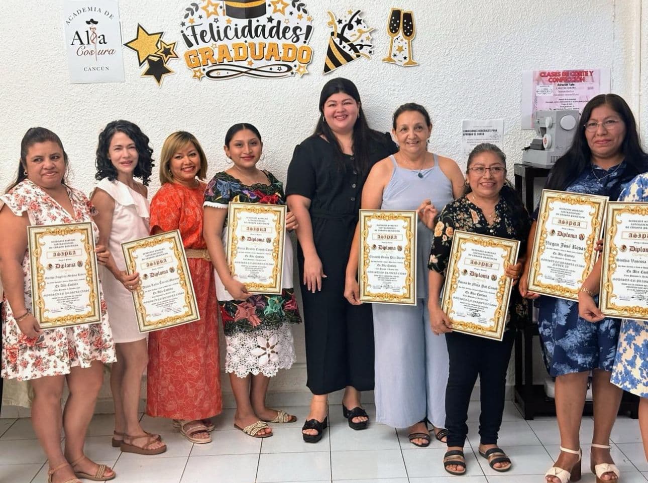 Grupo de siete alumnas con sus diplomas en el día de graduación