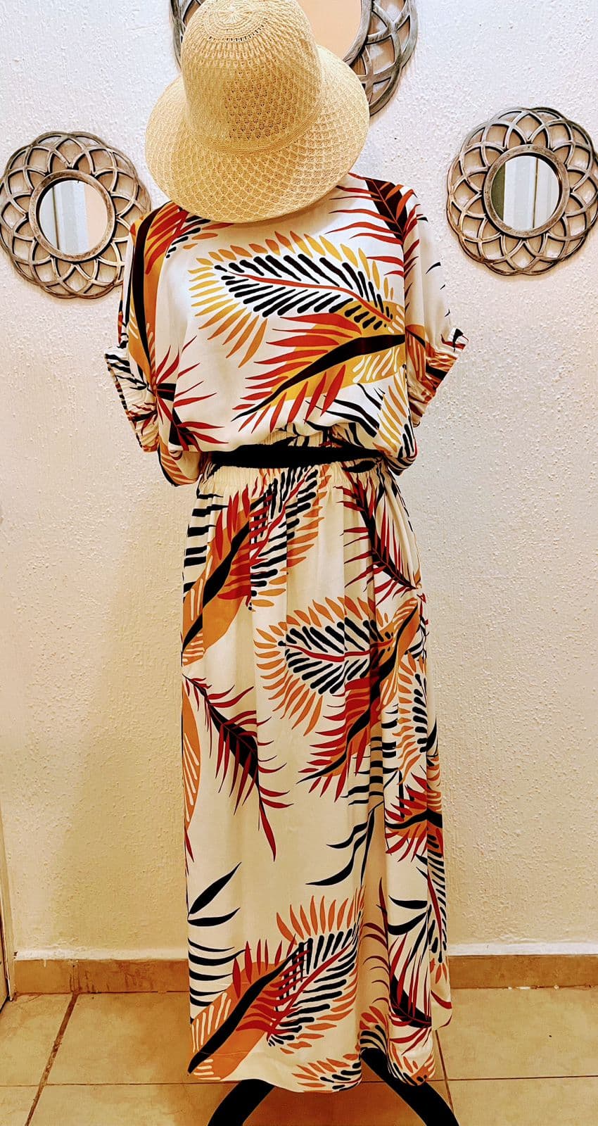 Vestido largo con estampado de palmas y sombrero panamá
