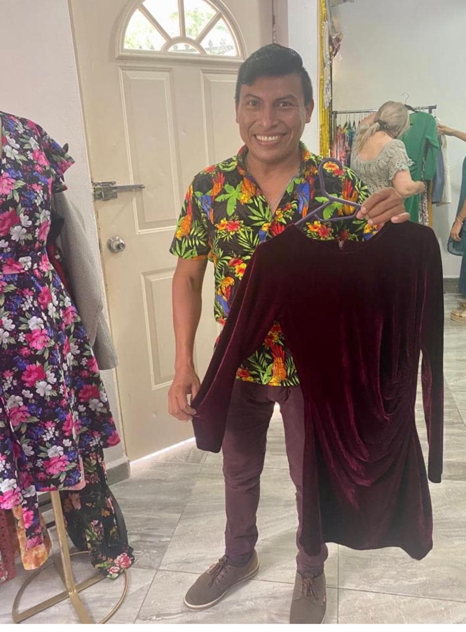 Alumno mostrando vestido largo de terciopelo color vino confeccionado por él